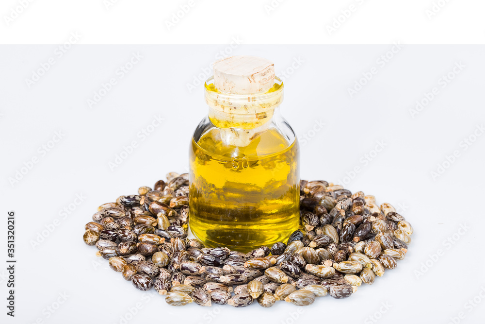 castor oil and grains in bowl isolated on white background castor oil and grains in bowl isolated on white background