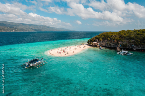 Aerial view of Sumilon Island's famous white sand bar in Oslob, Cebu, Philippines that attracts visitors every day because of its magnificent white sand beach and crystal-clear waters.