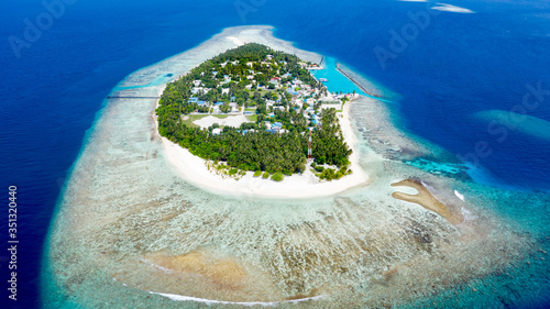 Aerial view of local island Omadhoo, located in Alif Dhaal Atoll, Maldives, Indian Ocean with reef, harbour, local beach and sandbank photo