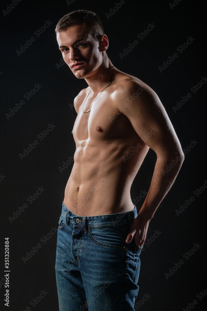 Portrait of a strong healthy handsome athletic man posing as a fitness model on dark background Portrait of a strong healthy handsome athletic man posing as a fitness model on dark background