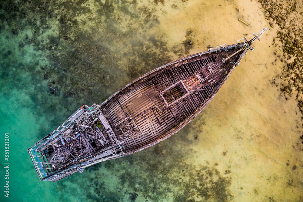 Aerial view of the abandoned old shipwreck at the coast of the Celebes Sea, Maratua Bohesilian near Borneo, Indonesia. Aerial view of the abandoned old shipwreck at the coast of the Celebes Sea, Maratua Bohesilian near Borneo, Indonesia.