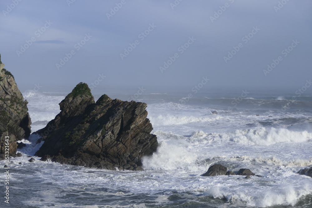 Strong surf with rocks and foaming sea on a beach