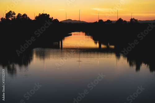 Silhouette of a bridge at sunset by a lake