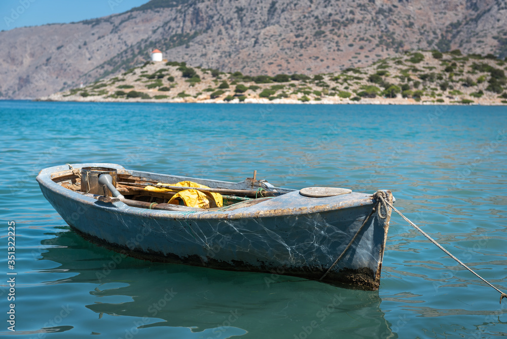 Traditional Greek fishing boat is moored near the coast at Symi island, Greece