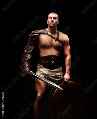 Gladiator with sword and armor on a black background