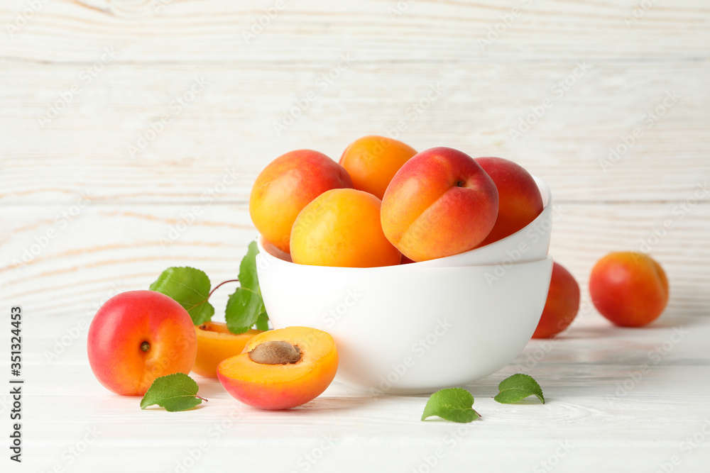 Bowl with tasty apricots on white wooden background Bowl with tasty apricots on white wooden background