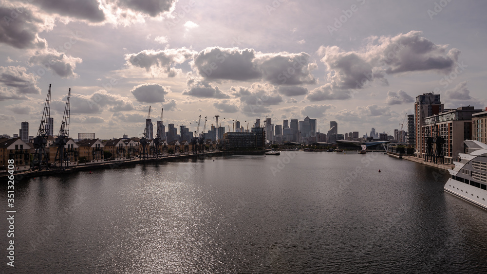 A View of part of London - Canary Wharf across the water surface with old ship cranes in the foreground