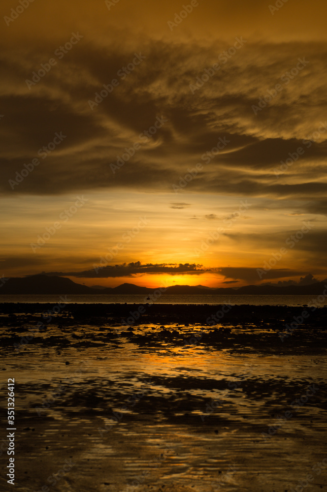 Obraz premium sunset at the beach with scared cloud