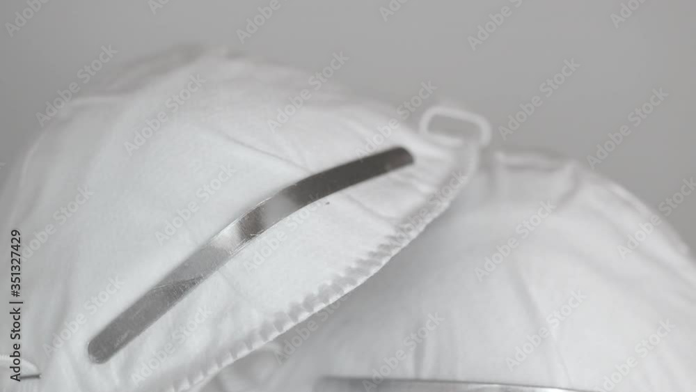 Closeup of face masks and stack of medicine blister pack on a white table, slow zoom out Closeup of face masks and stack of medicine blister pack on a white table, slow zoom out