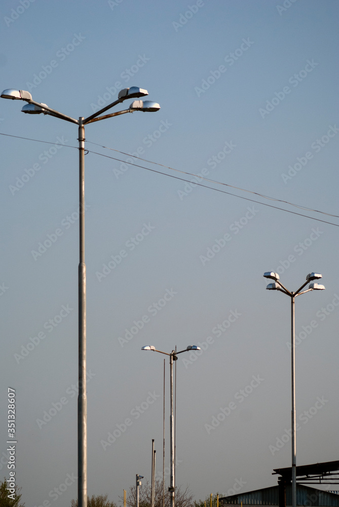 Pillars with street lighting against the blue sky Pillars with street lighting against the blue sky