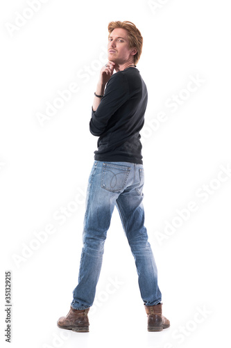 Rear view of cocky young handsome red hair man turning and looking at camera with head back. Full body length isolated on white background. 