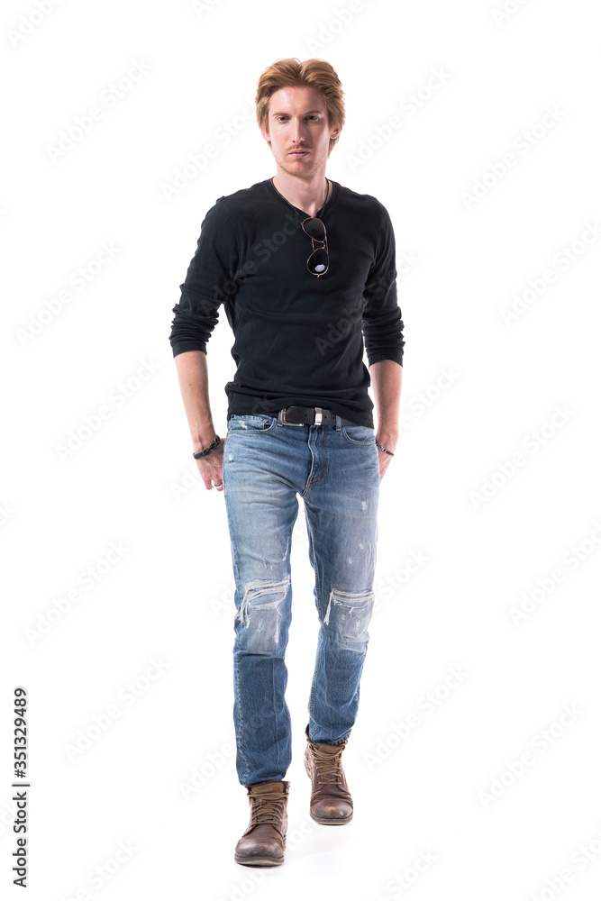 Front view of stylish modern young man walking and approaching to camera with hands in back pockets. Full body length isolated on white background. Front view of stylish modern young man walking and approaching to camera with hands in back pockets. Full body length isolated on white background.