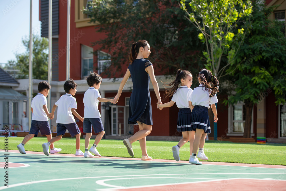 Teacher and students in kindergarten playground Teacher and students in kindergarten playground