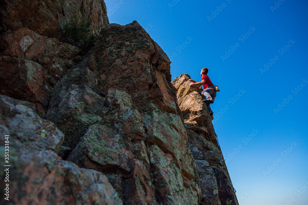 Rockclimber climbing up a steep piece of mountain