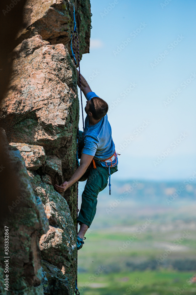 Fototapeta premium Young man finishing his extreme mountain climb
