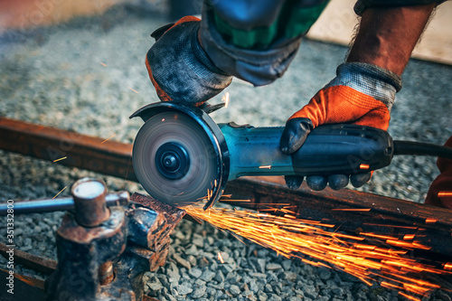 a man is sawing metal with an angle grinder.