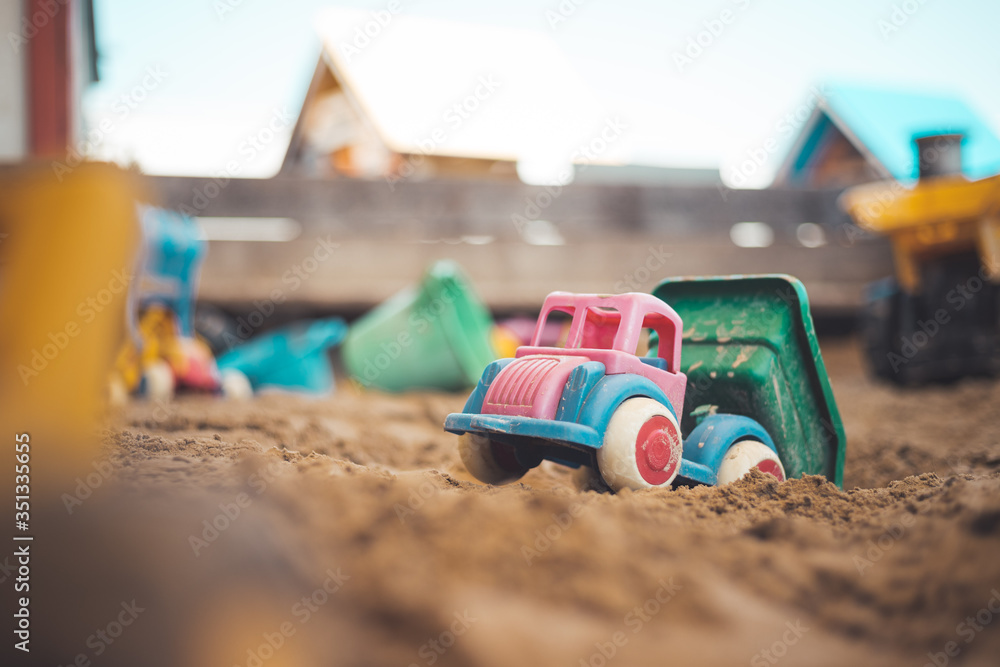 Childhood sandbox concept: Close up of plastic toy truck Childhood sandbox concept: Close up of plastic toy truck
