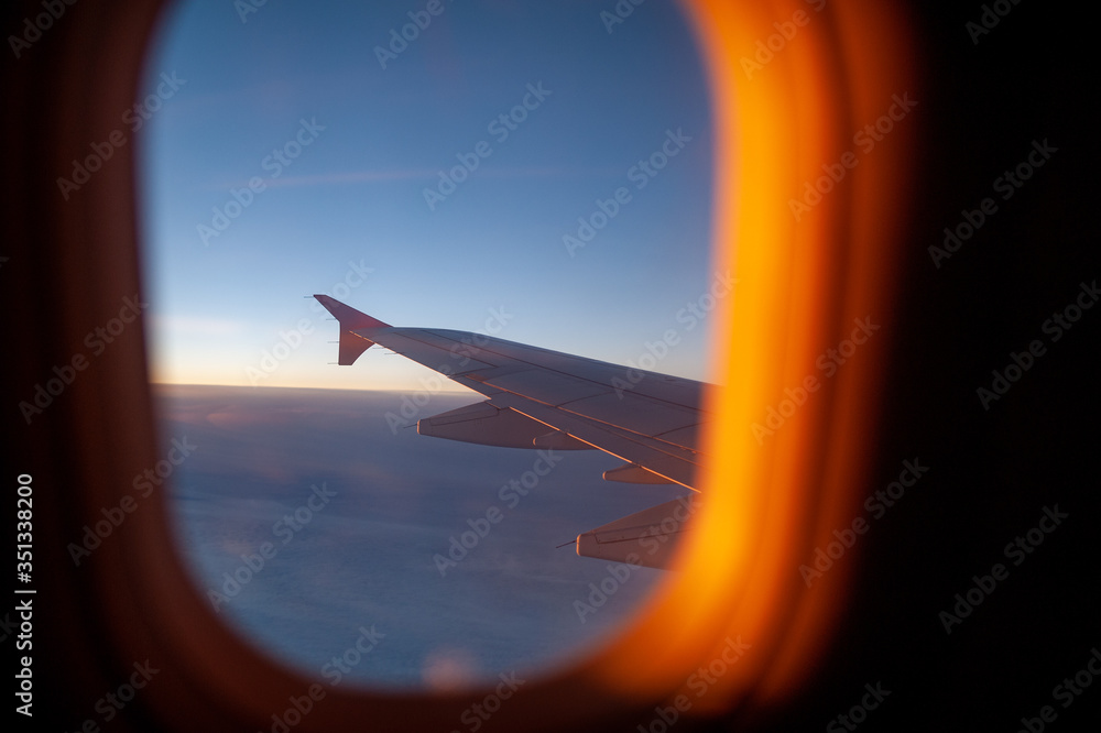 The wing of the plane visible through plane window
