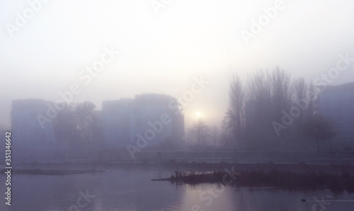 Foggy winter morning at urban riverside