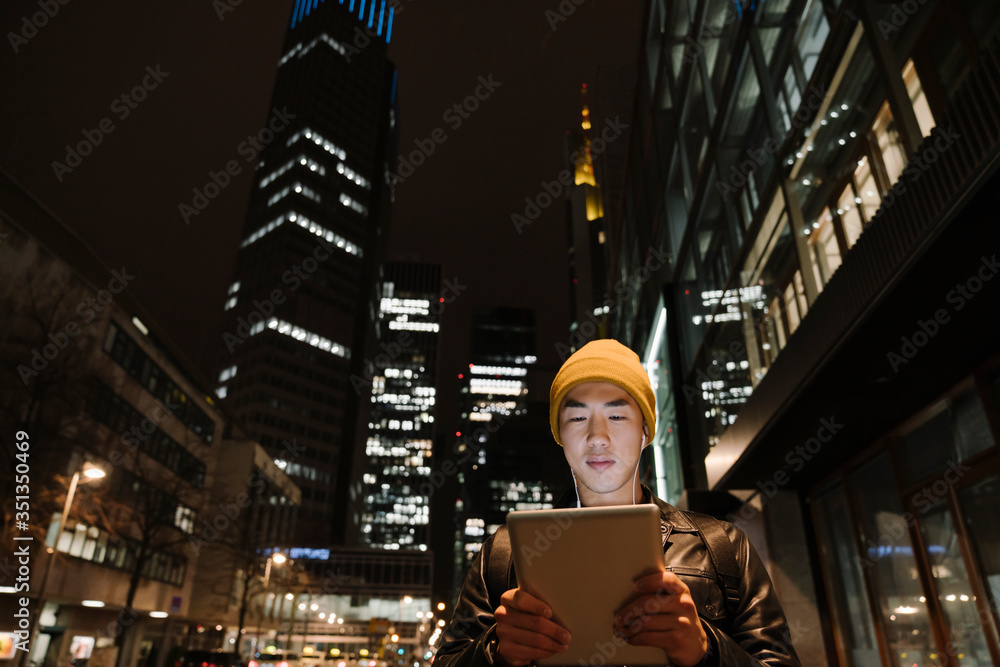 Man using tablet in the city at night Man using tablet in the city at night