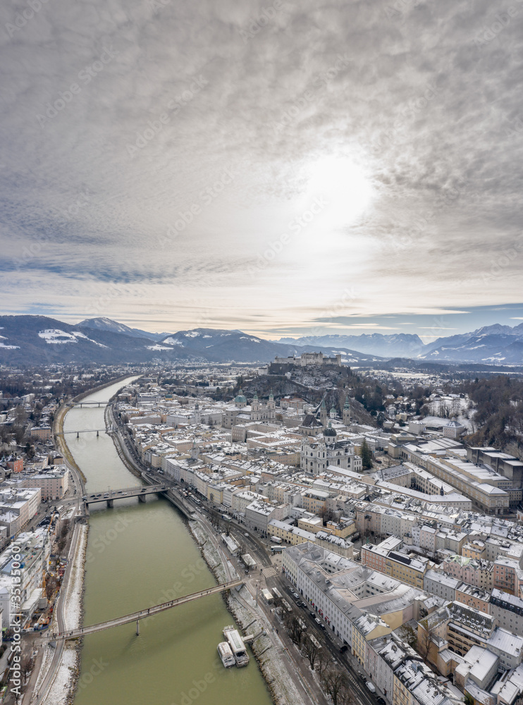 Aerial drone shot view of Salzburg Salzach river and Hohensalzburg fortress Untersberg snow mountain