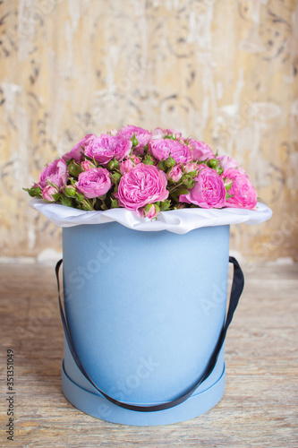 Fototapeta Naklejka Na Ścianę i Meble -  A bouquet of pink roses flowers in a blue round box