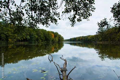 Obraz na plátně dark gloomy autumn day on little desolate natural lake, fallen trunk lies on bot