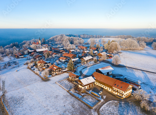 Germany, Bavaria, Hechenberg, Drone view of snow-covered countryside village at foggy dawn