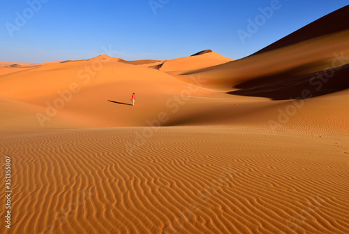 Africa, Algeria, Sahara, Tassili N'Ajjer National Park, Sand dunes of Tehak, One woman in the desert photo