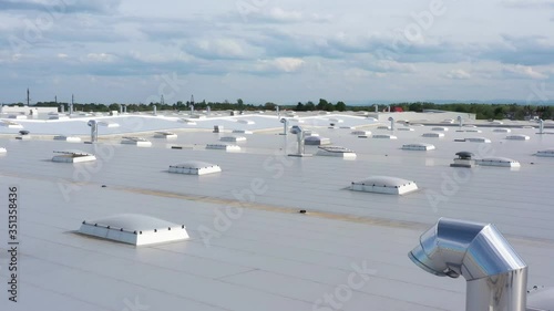 Ventilation system on the industrial building roof, HVAC. Themes of ventilation, technology, industry and creating safe working conditions. Drone flyover above roof, zoom in, 4k