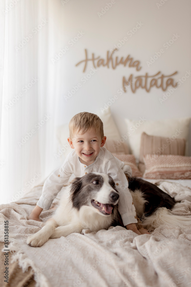 Portrait of happy little boy on bed with his dog Portrait of happy little boy on bed with his dog