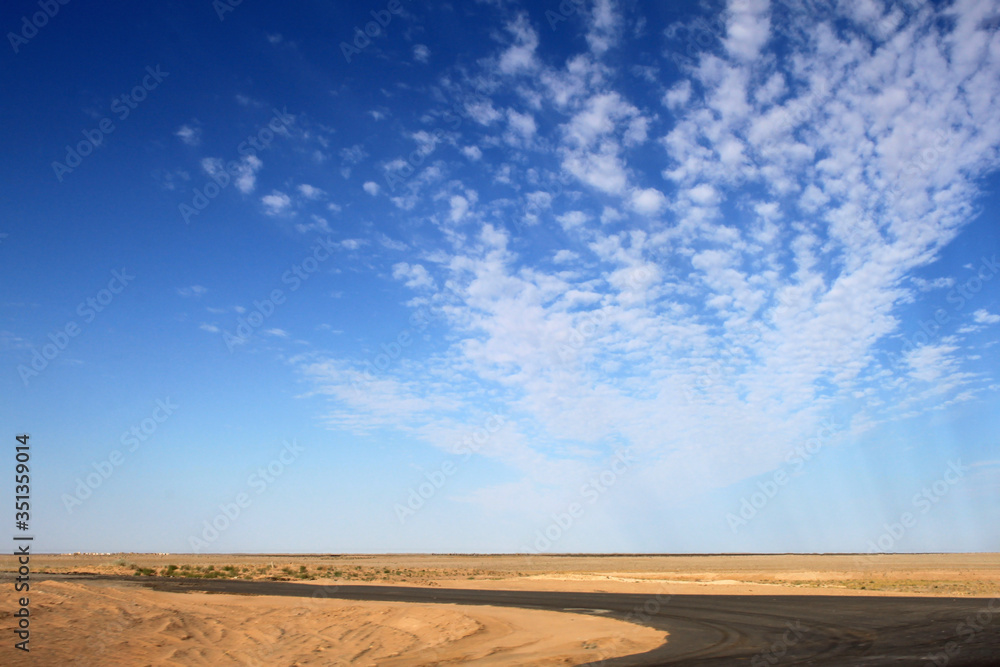 Desert terrain with sand. Nobody here. Blue sky with beautiful clouds. Desert terrain with sand. Nobody here. Blue sky with beautiful clouds.