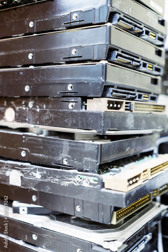 Pile of computer hard disks in recycling plant. Concept of electronic waste and management reuse recycle and recovery. Old E-waste device is ready for recycling.
