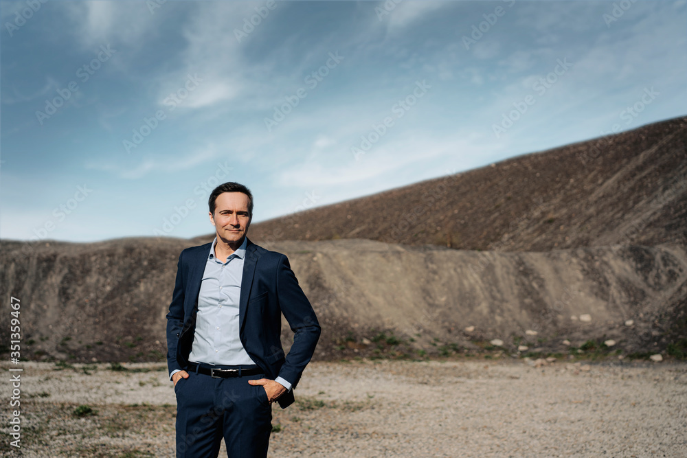 Portrait of a confident mature businessman on a disused mine tip Portrait of a confident mature businessman on a disused mine tip