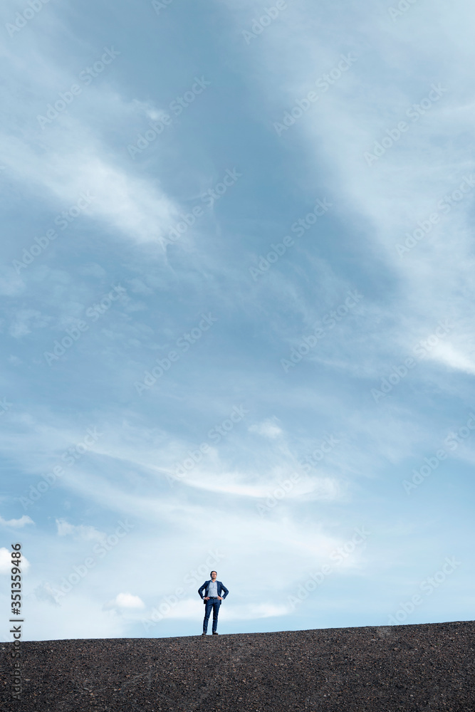 Mature businessman standing on a disused mine tip Mature businessman standing on a disused mine tip