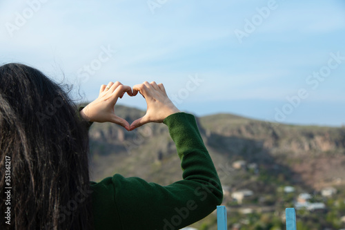 woman hand heart in nature