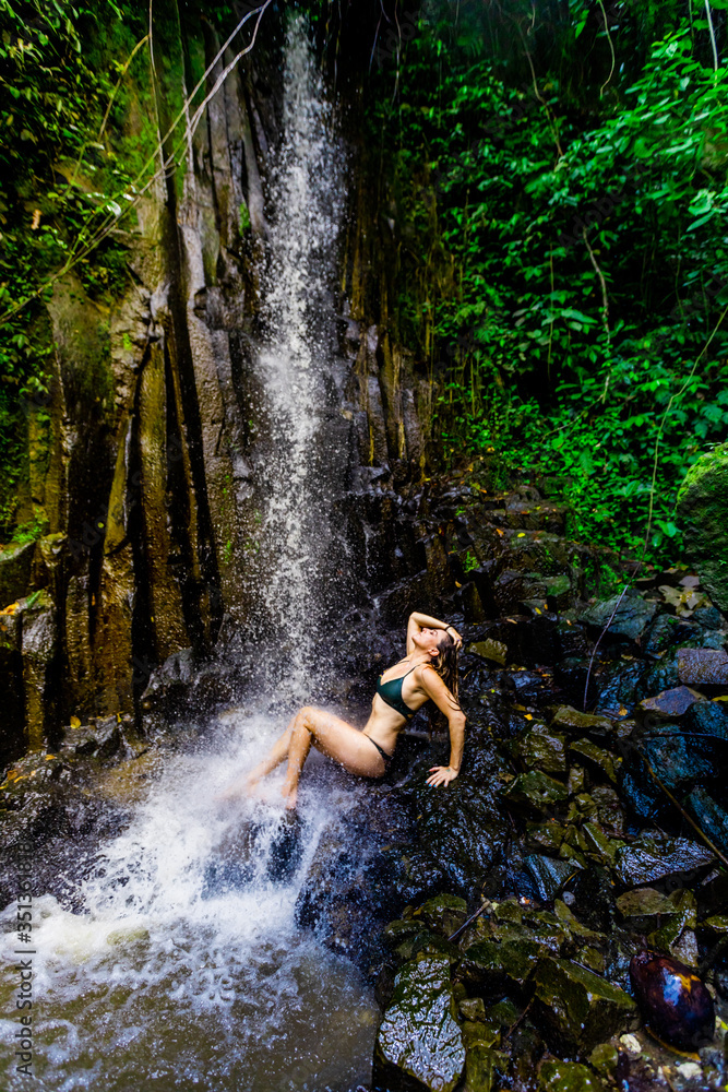 Woman posing for a picture under a waterfall at the Beji Guwang Hidden Canyon, Bali, Indonesia, Southeast Asia, Asia Woman posing for a picture under a waterfall at the Beji Guwang Hidden Canyon, Bali, Indonesia, Southeast Asia, Asia