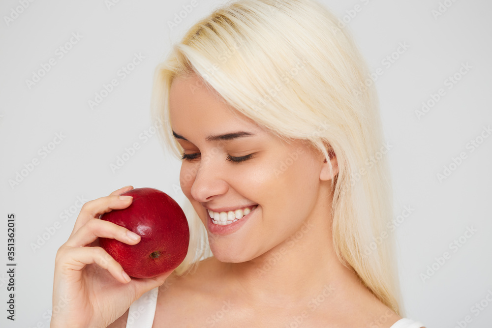 Woman with Apple. Beautiful girl with white smile on a gray background, healthy teeth. High Resolution Image Woman with Apple. Beautiful girl with white smile on a gray background, healthy teeth. High Resolution Image