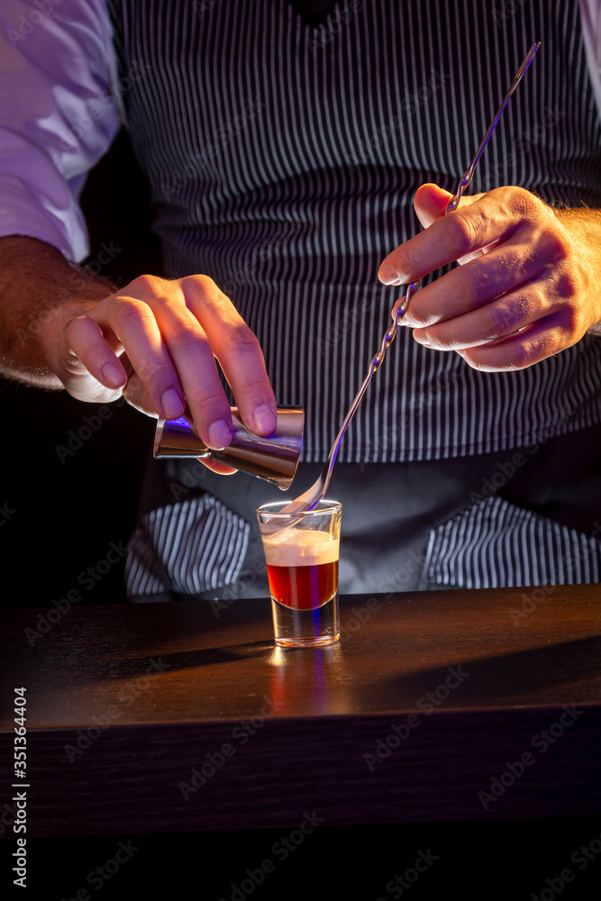 Bartender making B-52 layered cocktail shot