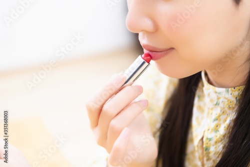 口紅を塗ってメイクする女性