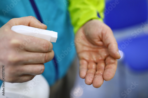 Man hold in hand white bottle of sanitizer