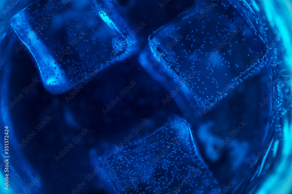 Blue sparkling water with ice cubes and bubbles macro close up Blue sparkling water with ice cubes and bubbles macro close up