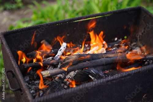 Close up of fire on chargrill. Dry sticks smoulder. Concept of cooking on grill.