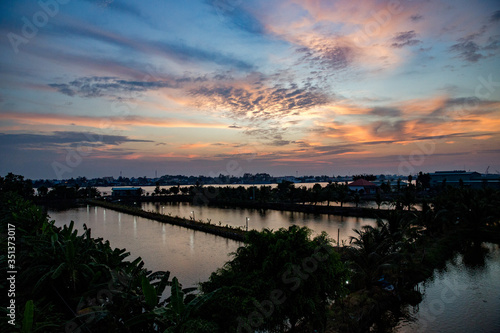 Vietnam, Cần Thơ, Bình Thủy, Zu Besuch auf der Insel Con Son (Cồn Sơn, Bùi Hữu Nghĩa,) in der Nähe von Cần Thơ der größte Stadt im Mekong-Delta und gleichzeitig die Hauptstadt des Mekong Delta. Wanderung zum Aussichtspunkt der Insel bei Sonnenuntergang. Blick über die Insel vom Aussichtspunkt., Begrünte Wege mit Palmen im Fluss bei Sonnenuntergang photo