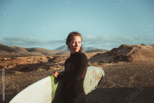 Spanien, Kanaren, La Oliva, Auf der Insel Fuerteventura. Eine Surferin am Strand von Punta Mallorquin ca. 3 km südlich von El Cotillo entfernt photo