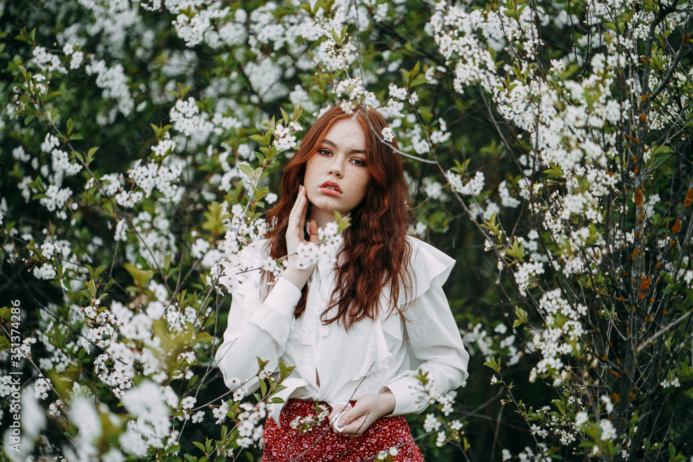 red-haired girl with freckles in cherry blossom red-haired girl with freckles in cherry blossom