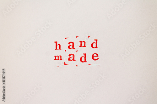 Hand made words made with letter stamps with red ink on white paper.