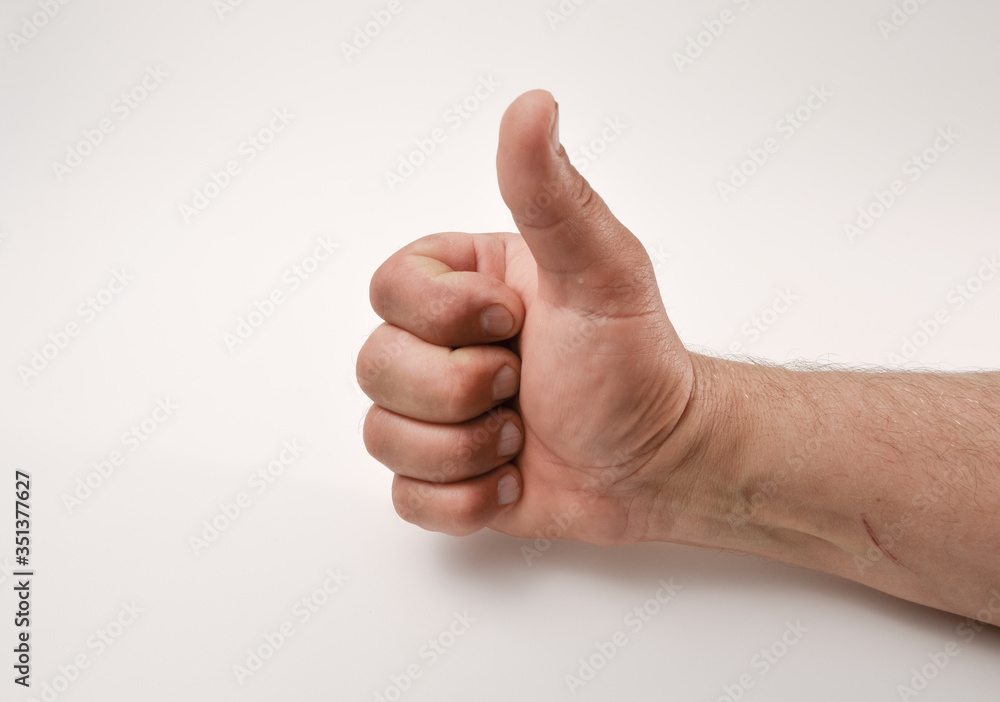 male hand is clenched into a fist with a thumb raised up yes, class, life