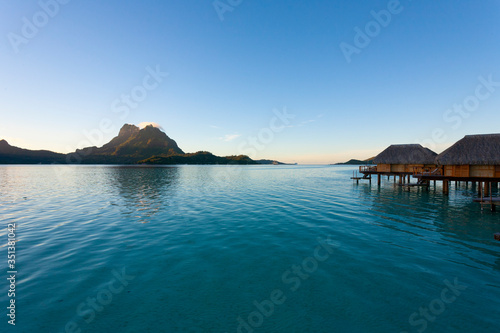 Bora Bora lagoon with overwater huts at sunrise