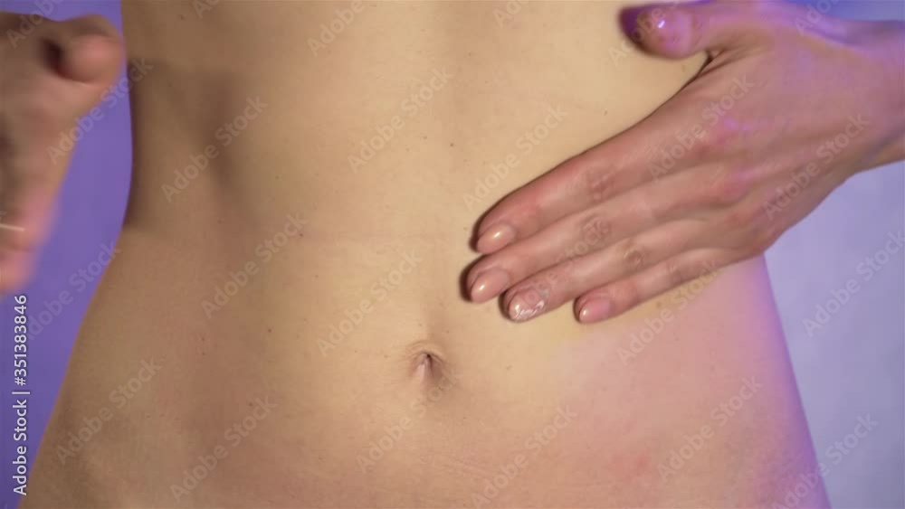 Close up young woman slaps her hands on her beautiful tummy. Concept of healthy food and lifestyle. Human body without clothes Close up young woman slaps her hands on her beautiful tummy. Concept of healthy food and lifestyle. Human body without clothes